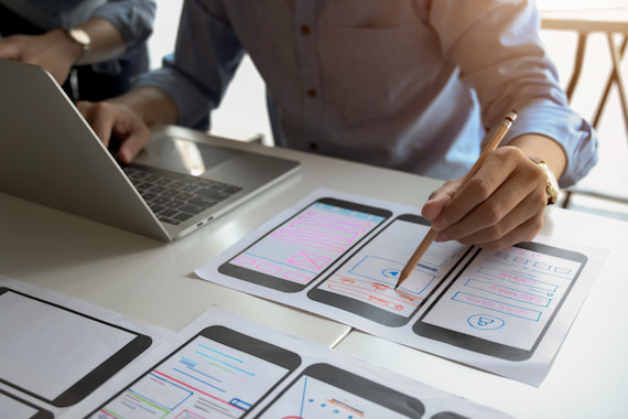 Mobile app developer looking at wireframes