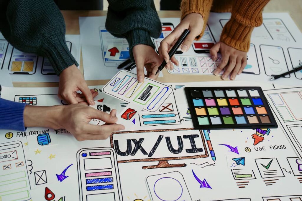 Team of designers showing on paper what is ui ux design