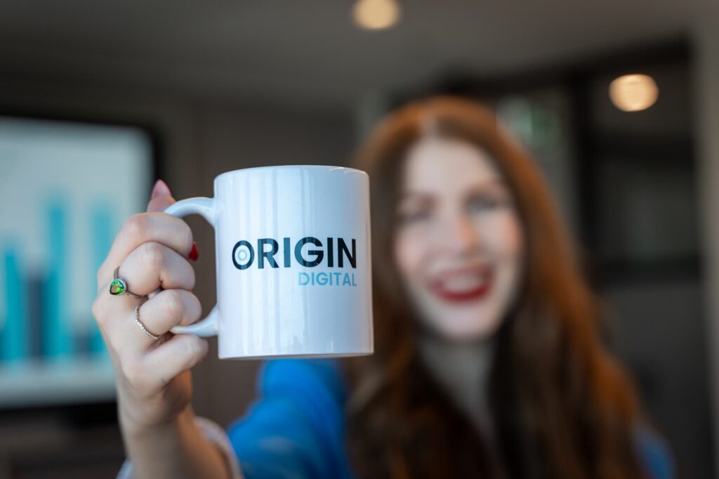 Consultant holding Origin Digital mug for cybersecurity compliance